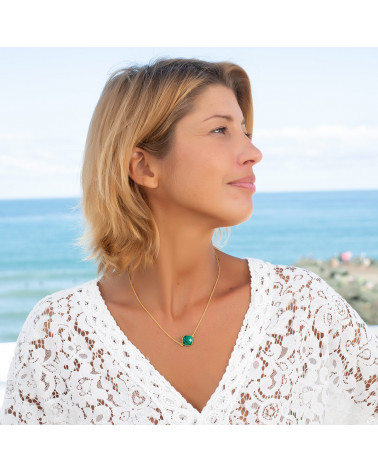 Collier doré à l'or fin et pierre d'émeraude porté par femme